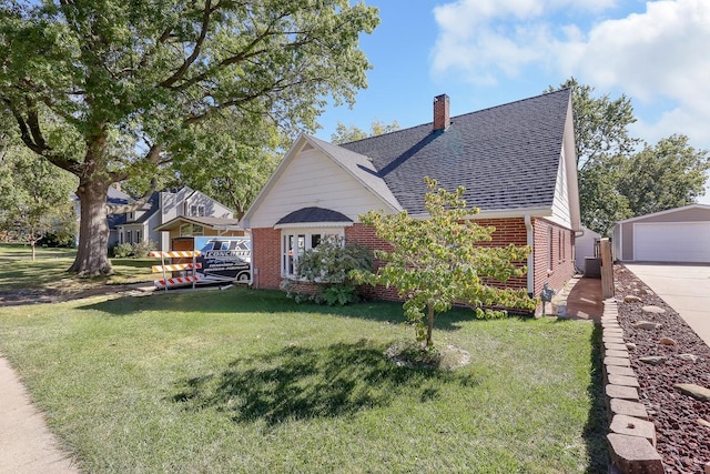 view of home's exterior with a chimney, roof with shingles, an outbuilding, a yard, and brick siding