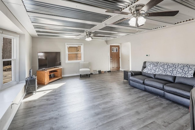 living room featuring a ceiling fan, baseboards, and wood finished floors