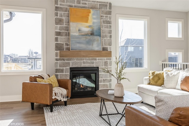 living room featuring a stone fireplace and hardwood / wood-style floors