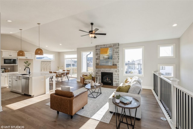 living room featuring a fireplace, a wealth of natural light, dark hardwood / wood-style floors, and ceiling fan