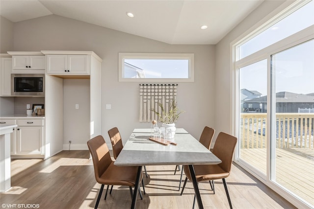 dining area featuring lofted ceiling and light hardwood / wood-style floors