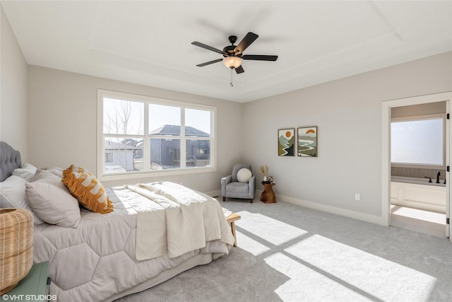 carpeted bedroom featuring a raised ceiling and ceiling fan