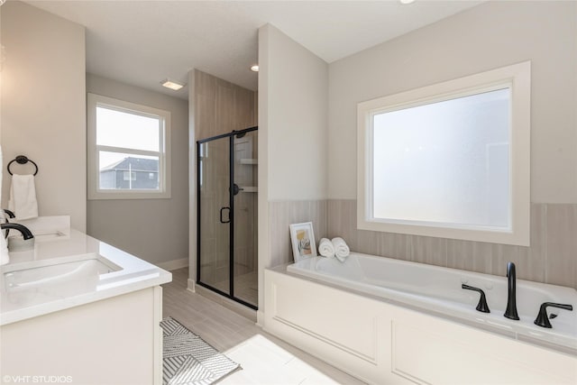 bathroom featuring tile patterned flooring, vanity, plenty of natural light, and plus walk in shower