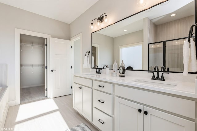 bathroom with a shower with door and vanity