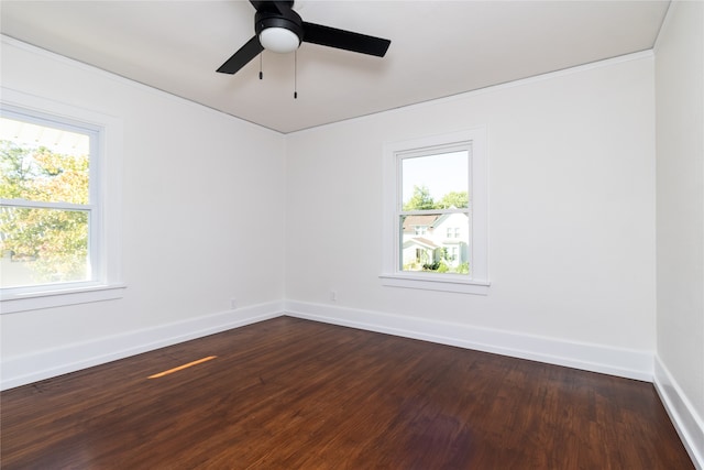 spare room with ceiling fan, dark wood-type flooring, and a wealth of natural light