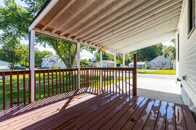 wooden terrace with a lawn, a storage shed, and a patio area