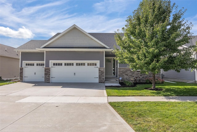 craftsman-style house featuring a front lawn and a garage