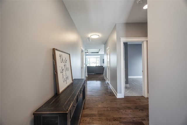 corridor featuring baseboards and dark wood-style flooring