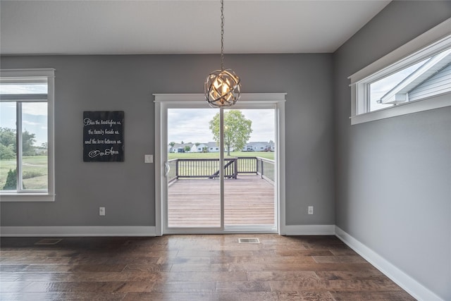 interior space featuring dark wood finished floors, visible vents, baseboards, and an inviting chandelier