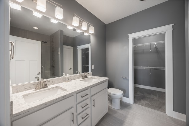 bathroom featuring toilet, vanity, and a shower with shower door