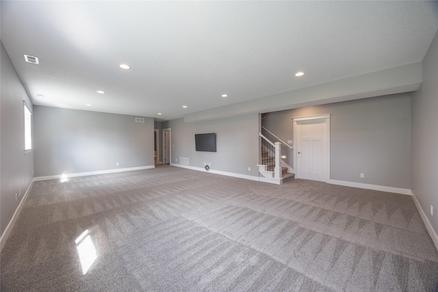 unfurnished living room with baseboards, stairs, visible vents, and carpet