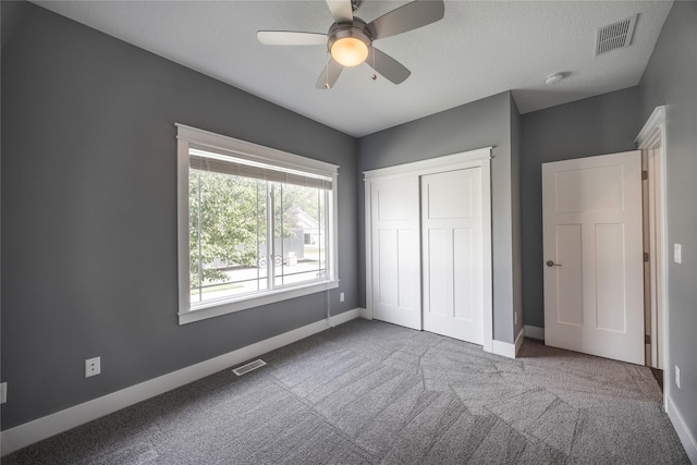 unfurnished bedroom with baseboards, carpet flooring, visible vents, and a closet