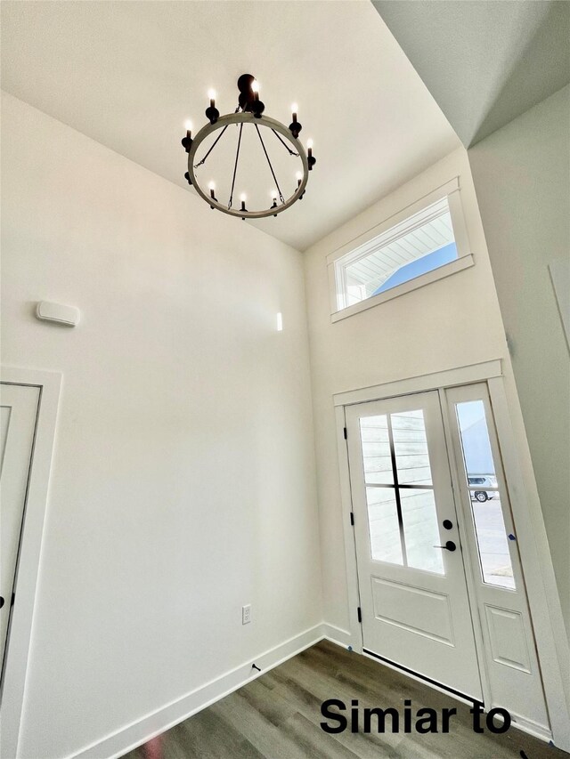 foyer featuring dark wood-type flooring and a chandelier