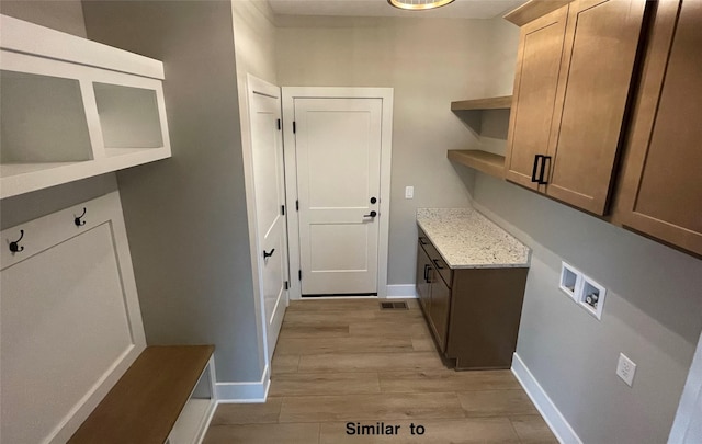 laundry area featuring cabinets, hookup for a washing machine, and light wood-type flooring