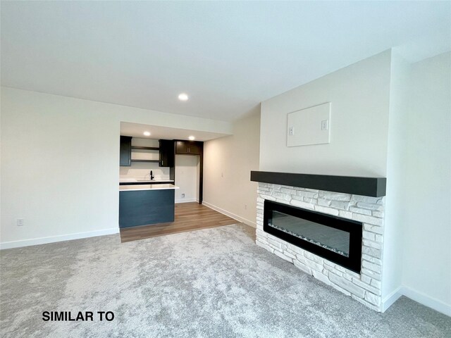 unfurnished living room featuring dark carpet and a fireplace