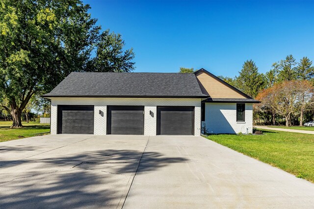 view of side of property with a lawn and a garage