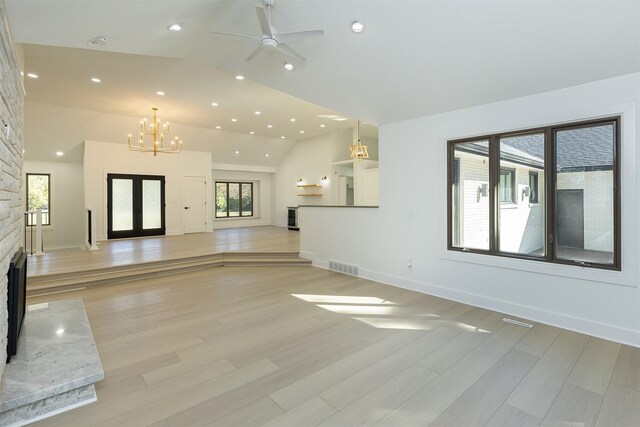 unfurnished living room featuring light hardwood / wood-style floors, a stone fireplace, and plenty of natural light