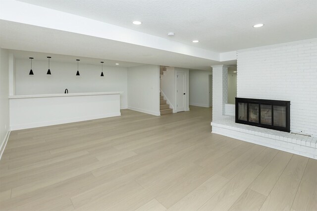 unfurnished living room featuring a fireplace and light hardwood / wood-style floors