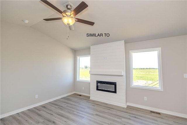 unfurnished living room with light wood-type flooring, a large fireplace, and lofted ceiling