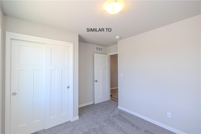 unfurnished bedroom with light carpet and a closet