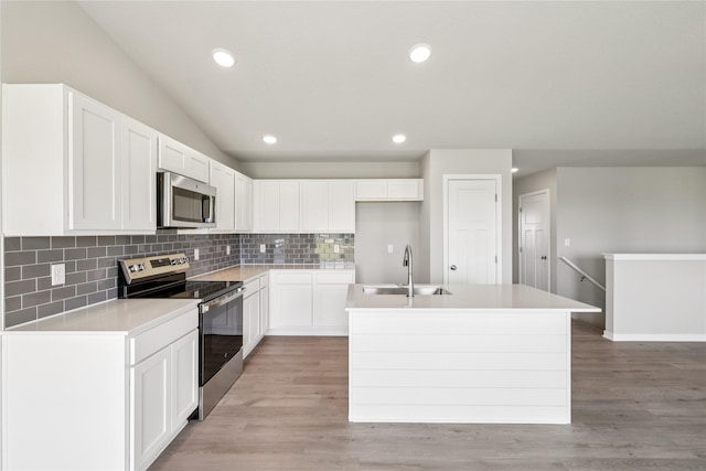 4428 NE 8th St, Ankeny, IA 50021 - kitchen with appliances with stainless steel finishes, decorative backsplash, a center island with sink, a sink, and white cabinetry