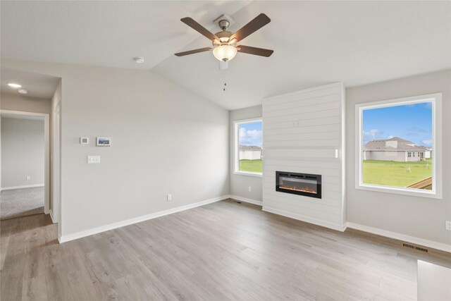 4428 NE 8th St, Ankeny, IA 50021 - unfurnished living room featuring a large fireplace, wood finished floors, a ceiling fan, baseboards, and lofted ceiling