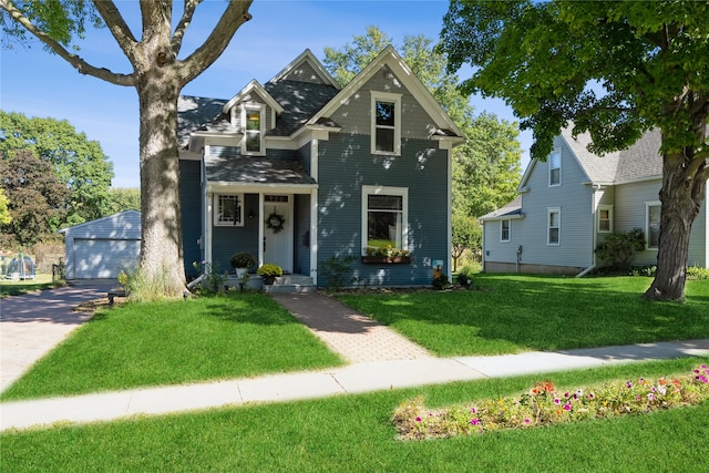 view of front of property featuring an outbuilding, a garage, and a front yard