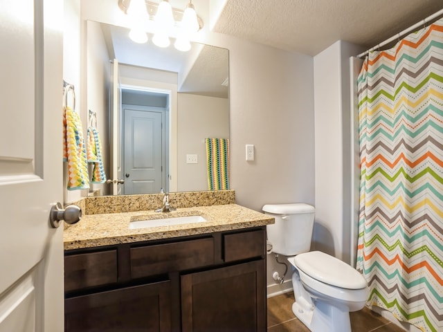 bathroom with vanity, a textured ceiling, walk in shower, toilet, and tile patterned floors