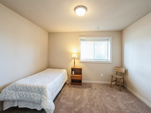 bedroom with a textured ceiling and carpet