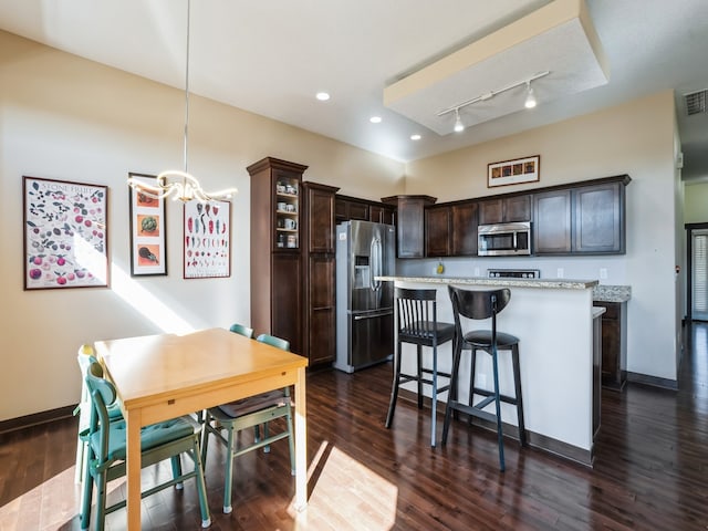 kitchen featuring a breakfast bar, dark hardwood / wood-style flooring, stainless steel appliances, dark brown cabinets, and a center island