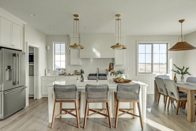 kitchen with white cabinetry, premium appliances, and hanging light fixtures