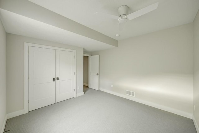 unfurnished bedroom featuring ceiling fan, a closet, and light carpet