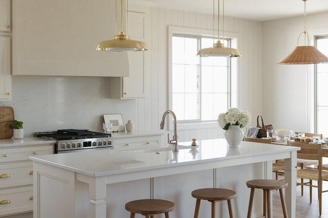 kitchen with gas range oven, a breakfast bar area, light countertops, and decorative backsplash