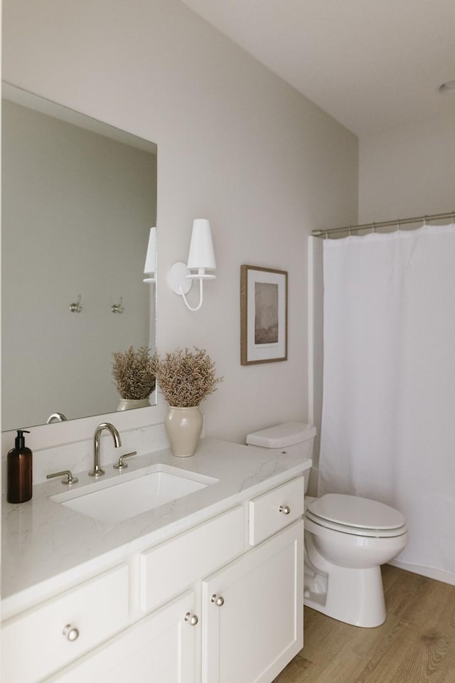 full bath featuring vanity, a shower with shower curtain, wood finished floors, and toilet