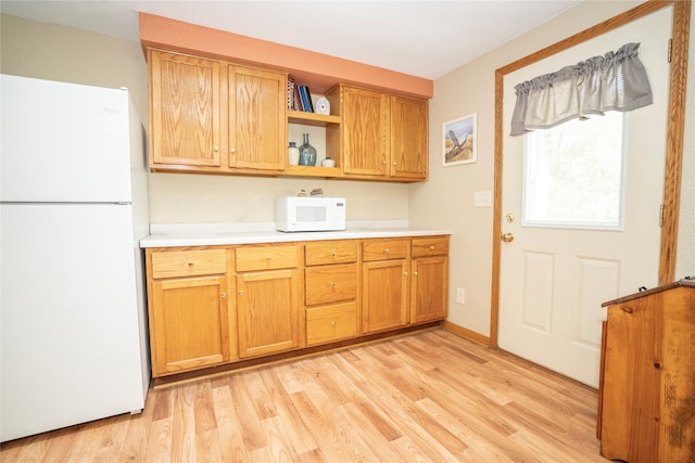 kitchen with light hardwood / wood-style flooring and white appliances