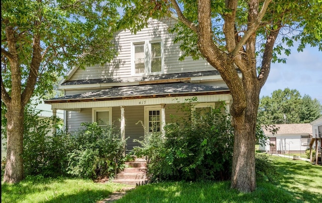 view of property hidden behind natural elements with covered porch