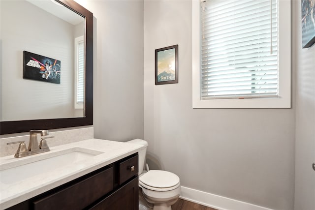 bathroom with wood-type flooring, vanity, and toilet