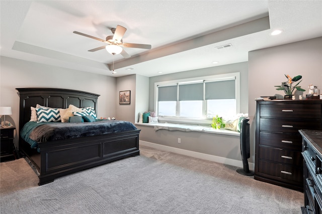 bedroom with a tray ceiling, ceiling fan, and light colored carpet