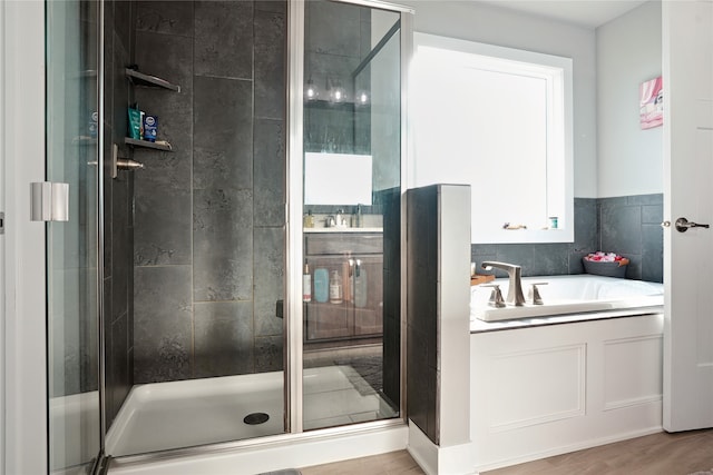 bathroom with independent shower and bath and hardwood / wood-style floors