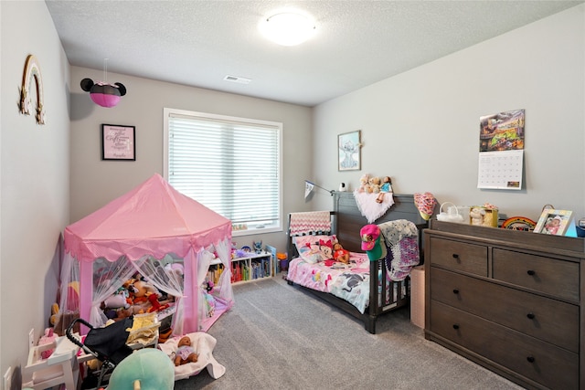 bedroom with light carpet and a textured ceiling