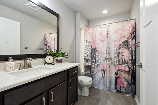 bathroom featuring walk in shower, vanity, toilet, and hardwood / wood-style flooring