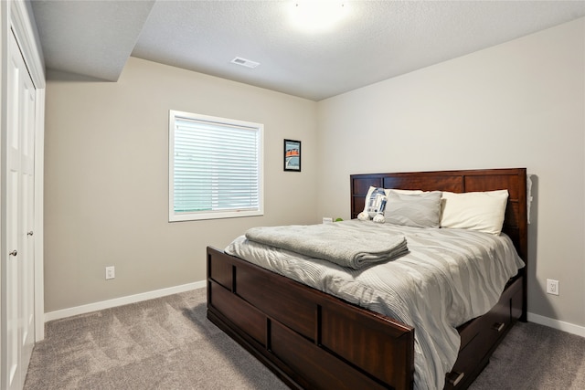 bedroom featuring a textured ceiling and light colored carpet