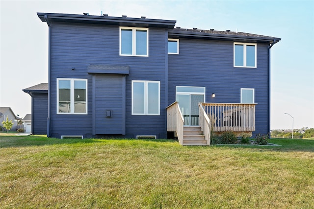 rear view of house with a lawn and a deck