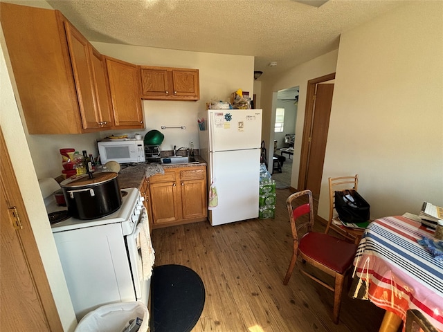 kitchen featuring white appliances, light wood-type flooring, a textured ceiling, ceiling fan, and sink