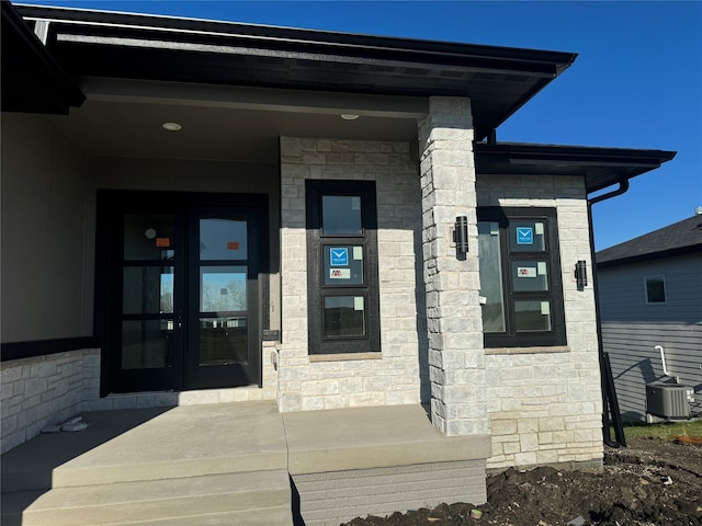 property entrance featuring french doors, a porch, and cooling unit