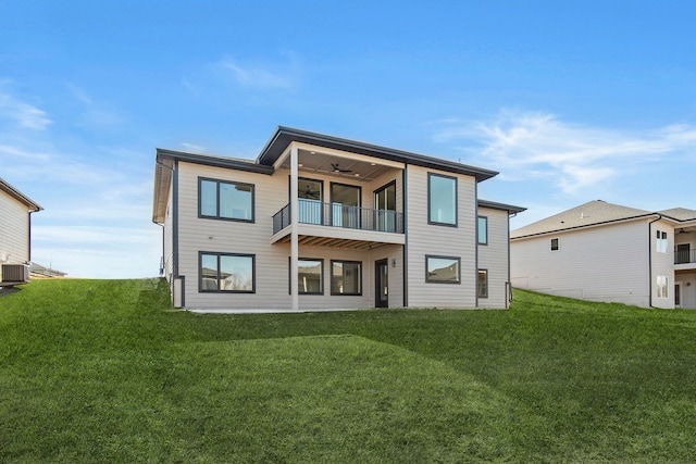 back of property with a yard and a balcony