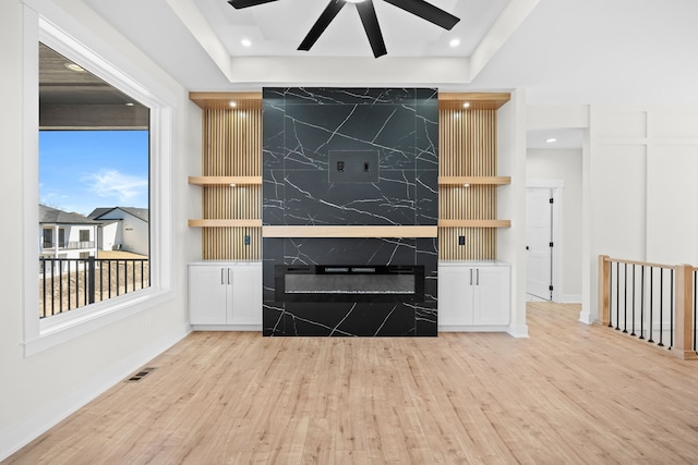 unfurnished living room with recessed lighting, wood finished floors, visible vents, and a premium fireplace