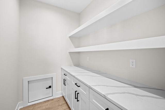 laundry room with light wood finished floors and baseboards