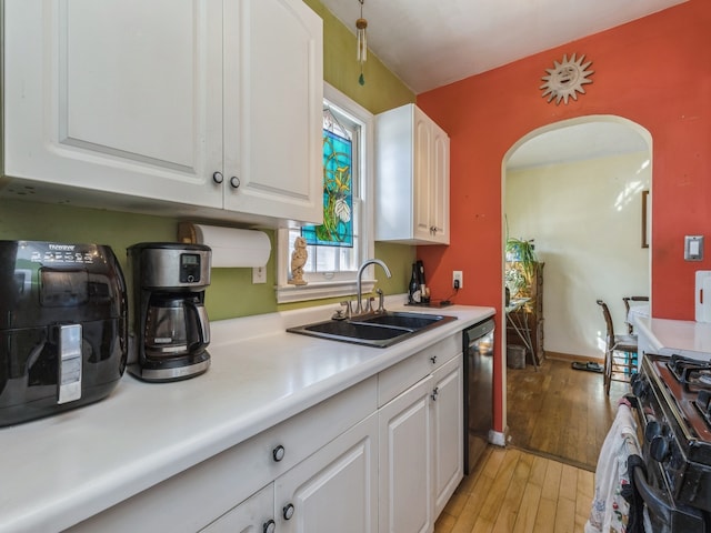 kitchen with black appliances, white cabinetry, light hardwood / wood-style floors, and sink