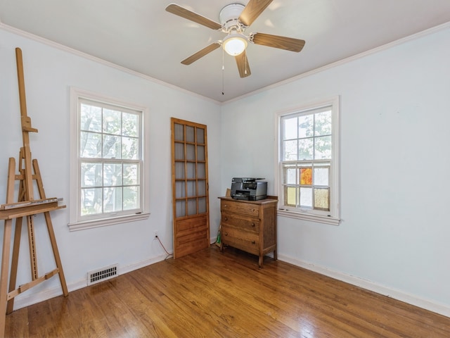 empty room featuring a healthy amount of sunlight, light hardwood / wood-style floors, and ornamental molding